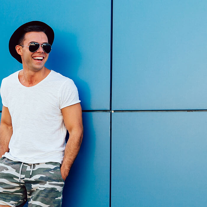 Smiling young man posting a comment about his great shopping experience.