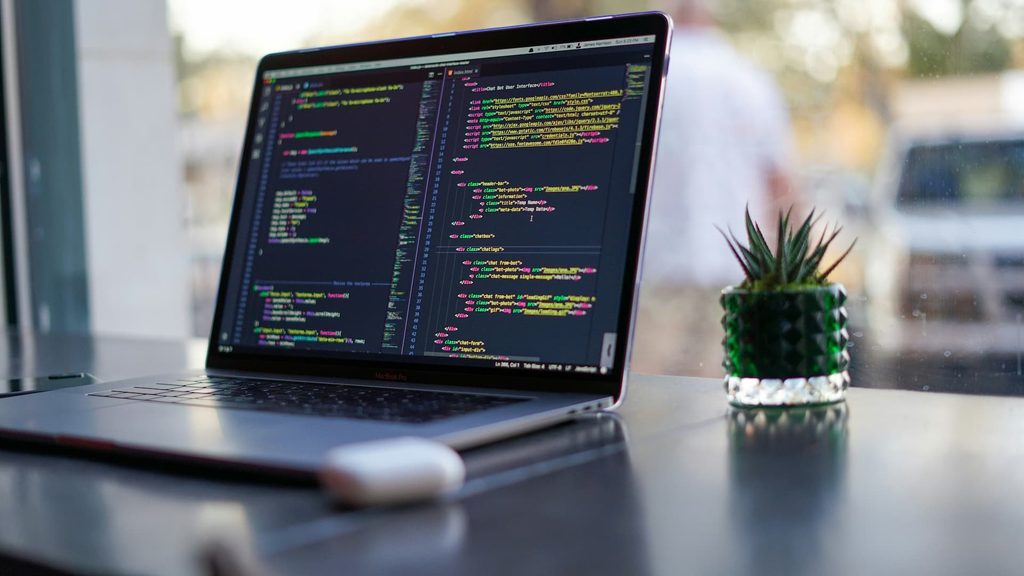 james-harrison-vpOeXr5wmR4-unsplash Modern developer workspace with laptop showing web development and technical SEO code by IntegBizz